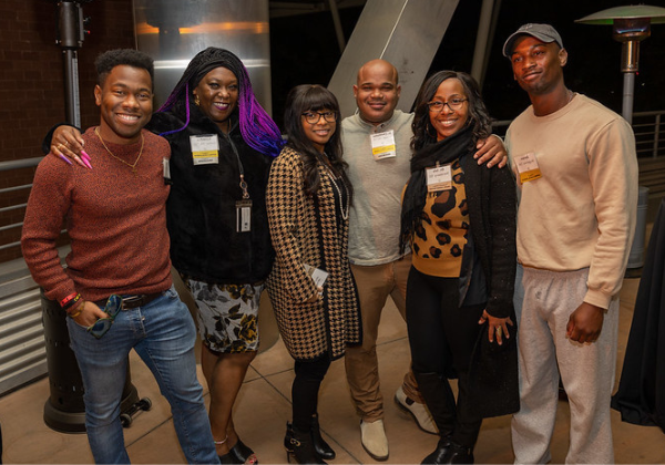 Six alumni posing with big smiles at the Black Alumni Network Mixer